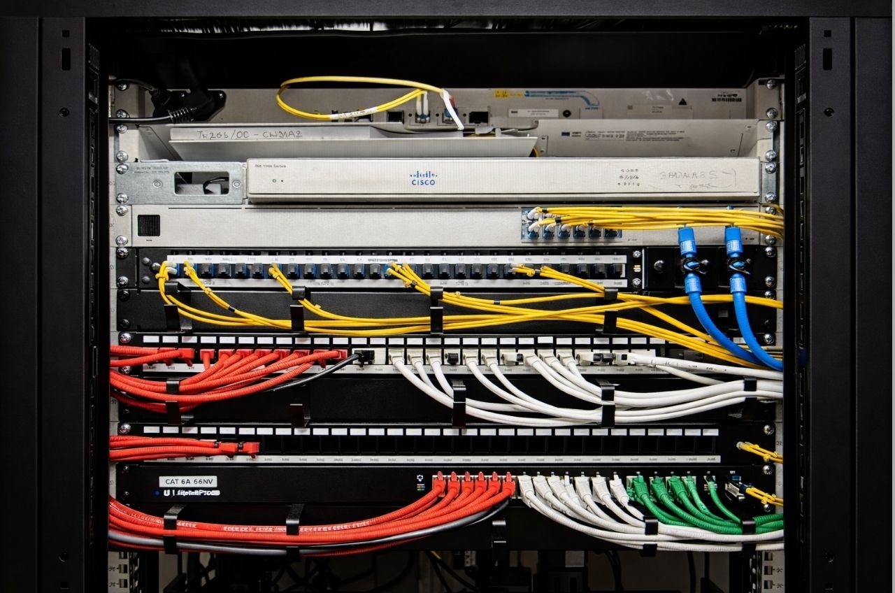 Structured cabling installation showing labelled patch panels for CCTV, door access control and network systems with neatly managed Ethernet cables in a commercial server rack.